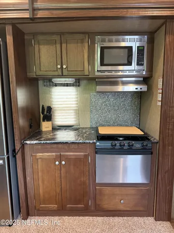 a kitchen with stainless steel appliances granite countertop a stove and a microwave