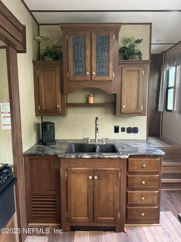 a kitchen with kitchen island granite countertop a sink cabinets and stainless steel appliances