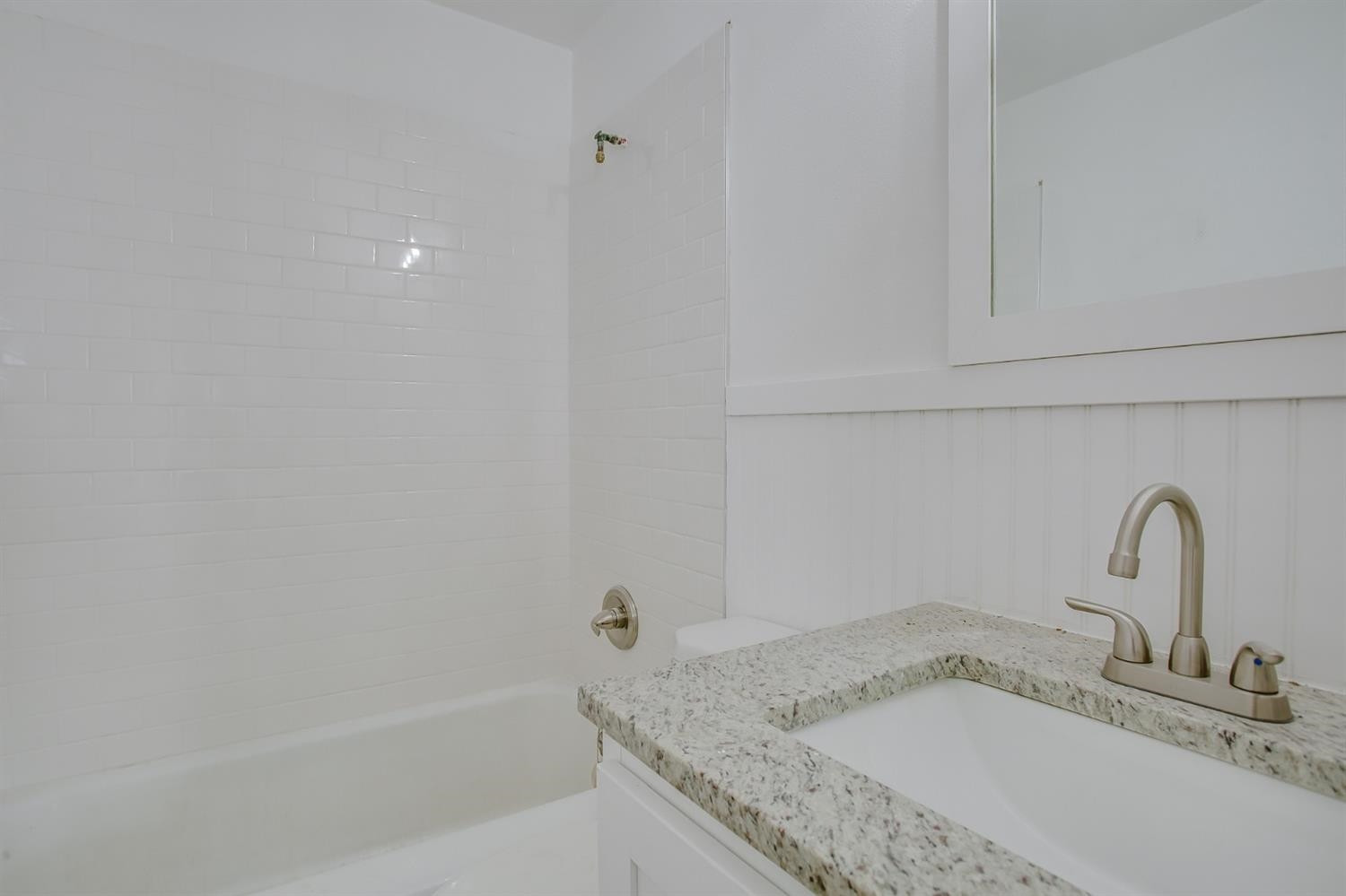 5002 41st Street Lubbock, TX 79414 - Photo 7 of 13 a bathroom with a granite countertop sink and vanity