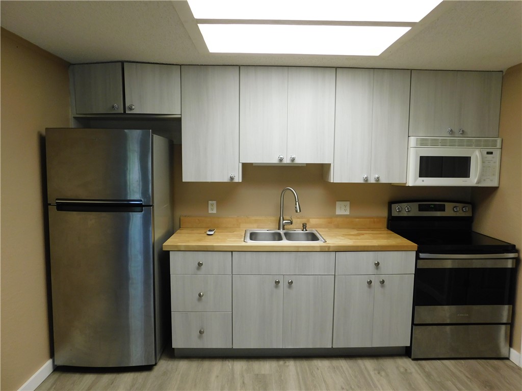 532 7th Place, Unit 532 Vero Beach, FL 32962 - Photo 2 of 8 a kitchen with a sink and a refrigerator
