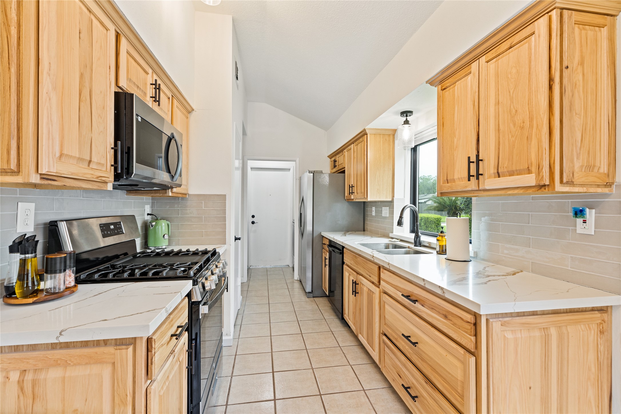 9719 Orangevale Drive Spring, TX 77379 - Photo 12 of 32 Updated kitchen with attractive quartz counters and tile backsplash.