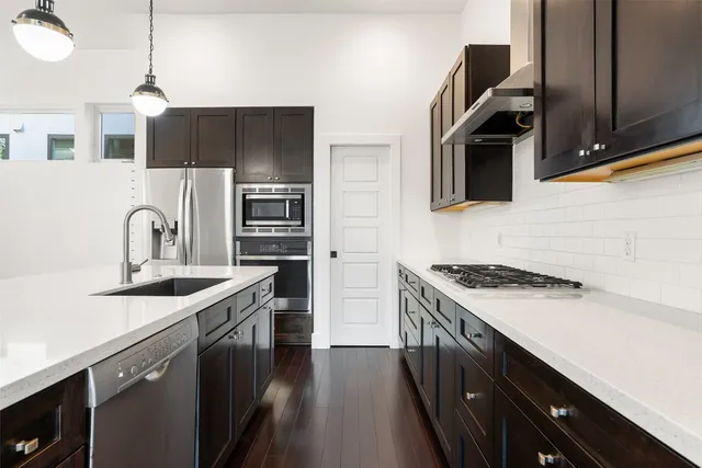 a kitchen with stainless steel appliances a sink stove and refrigerator