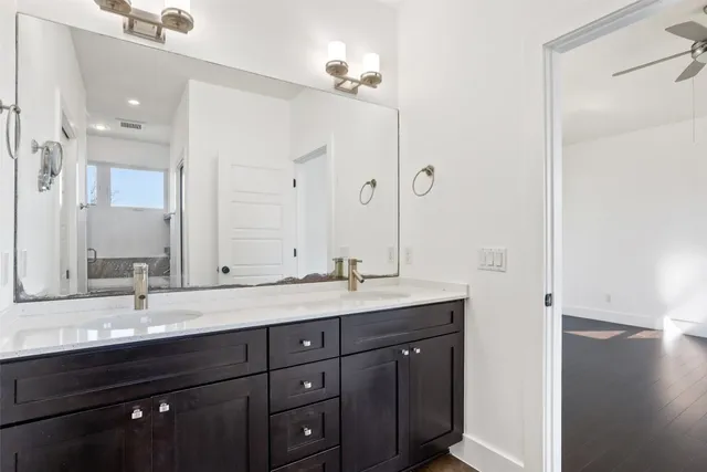 a bathroom with a granite countertop sink double and mirror