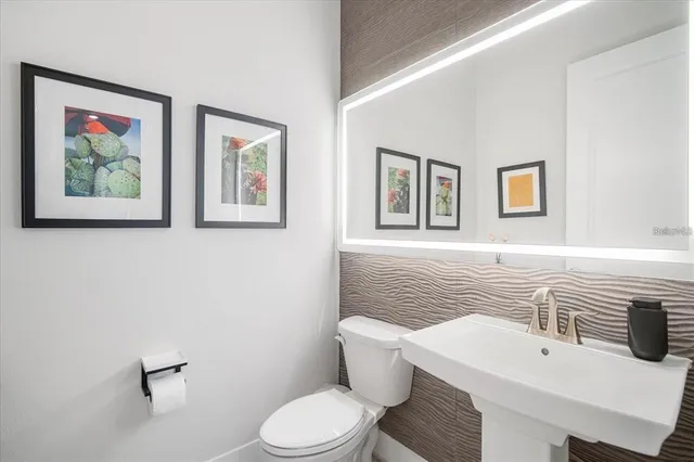 a bathroom with a toilet a sink and mirror