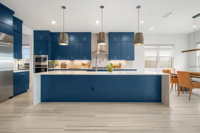 a kitchen with stainless steel appliances granite countertop a sink a stove and a wooden floors