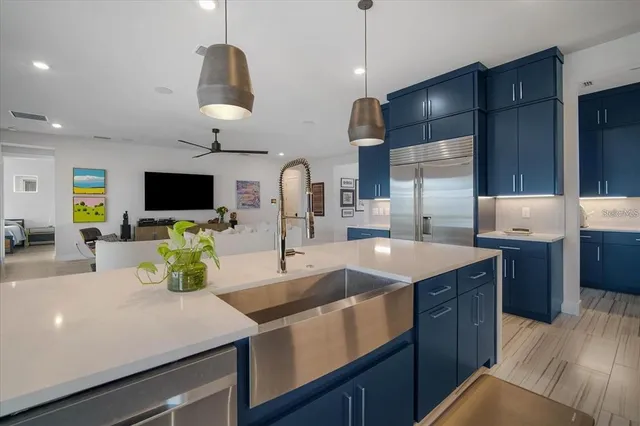 a kitchen with stainless steel appliances kitchen island granite countertop a sink a stove and a refrigerator