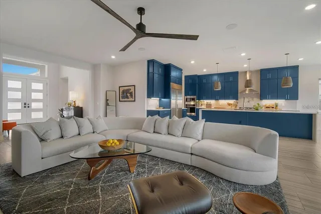 a living room with furniture kitchen view and a wooden floor