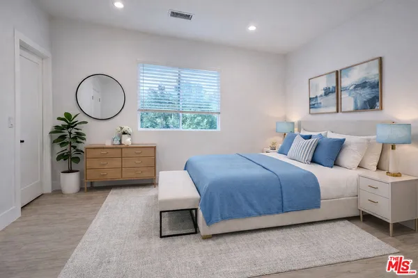 a bed room with a bed mirror and a window