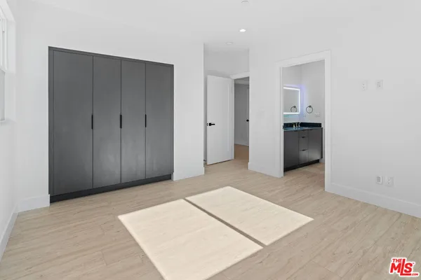 a view of a room with a hallway and wooden cabinets