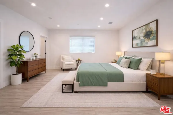 a bedroom with a bed and a potted plant