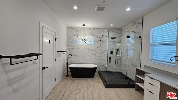 a bathroom with a tub a sink and a shower