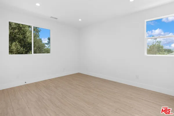 an empty room with wooden floor and a window
