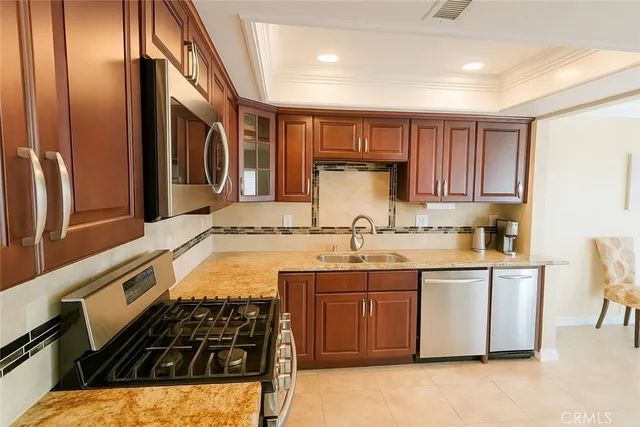 a kitchen with stainless steel appliances granite countertop a sink stove and refrigerator