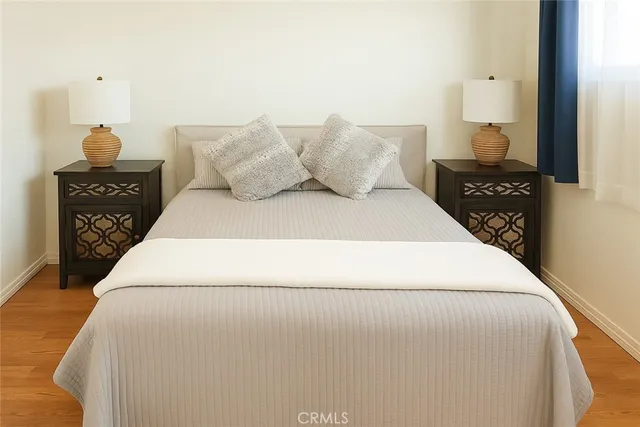 a bedroom with a bed and wooden floor