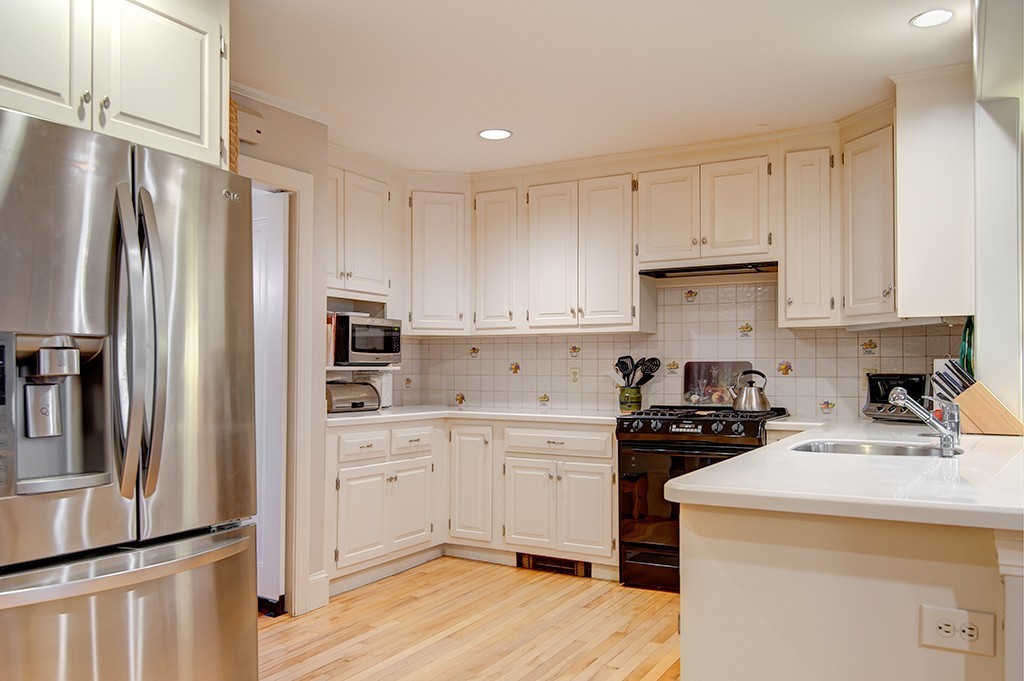 61 Silver Hill Road Weston, MA 02493 - Photo 5 of 18 a kitchen with a sink a refrigerator and white cabinets