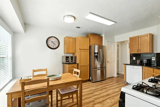a kitchen with a refrigerator and a stove top oven