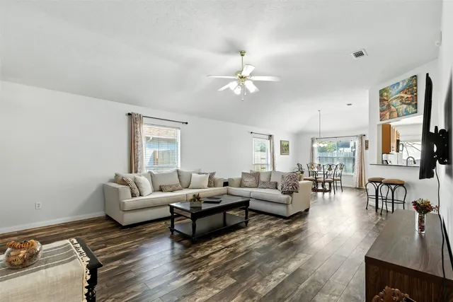 a living room with furniture chandelier and a window