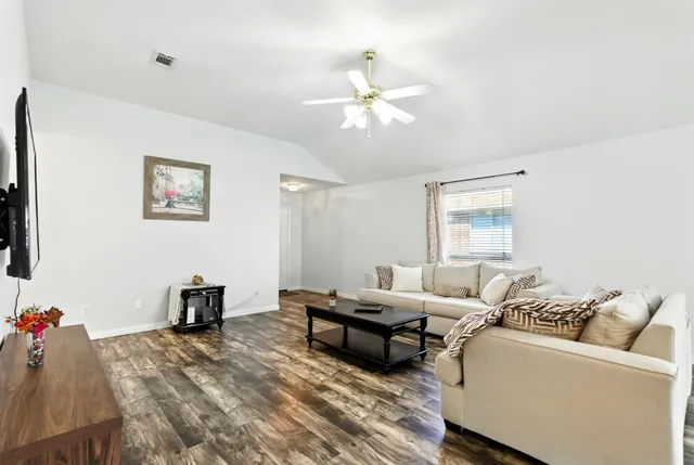 a living room with furniture and wooden floor