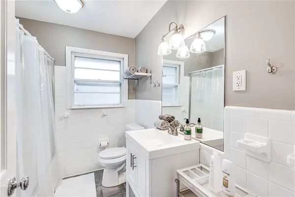 a bathroom with a sink a toilet and a mirror