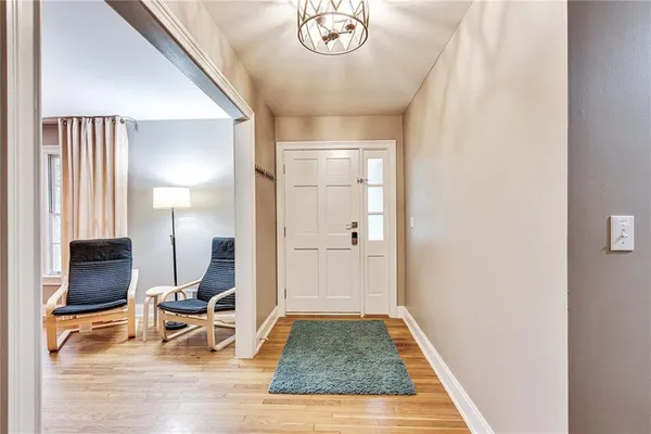 a view of a hallway with wooden floor and a living room