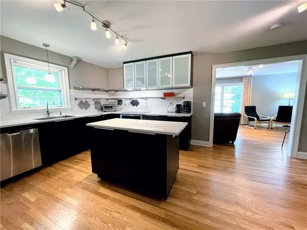 a kitchen with a sink cabinets and wooden floor