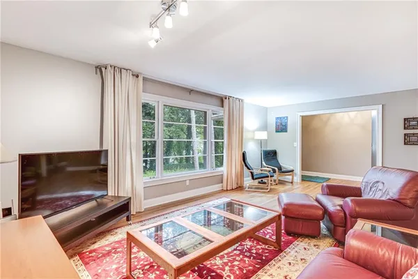 a living room with furniture a flat screen tv and a large window