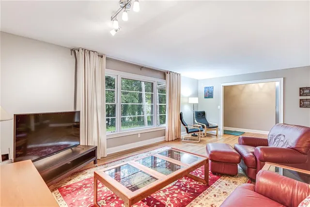 a living room with furniture a flat screen tv and a large window