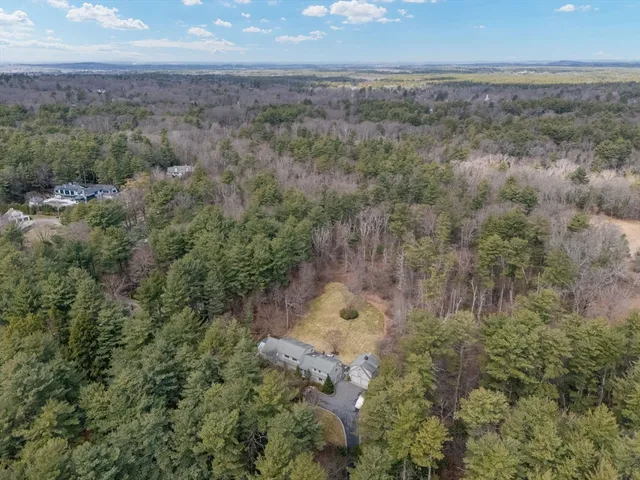 an aerial view of house with trees all around