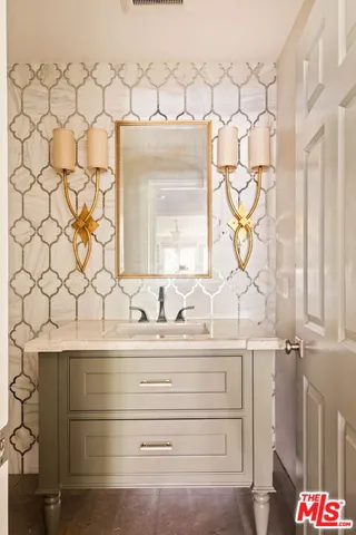 a bathroom with a granite countertop sink a mirror and a shower