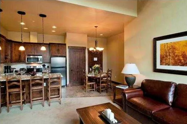 a living room with furniture kitchen view and a chandelier