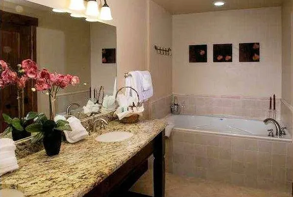 a bathroom with a granite countertop sink a mirror and vanity