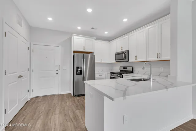 a kitchen with refrigerator cabinets and wooden floor