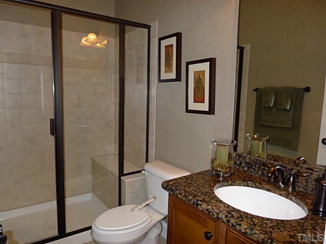 9811 Carvel Court Raleigh, NC 27613 - Photo 20 of 25 The first floor bathroom features granite coutertop and convenient step-in shower with bench and tile walls. Bathroom