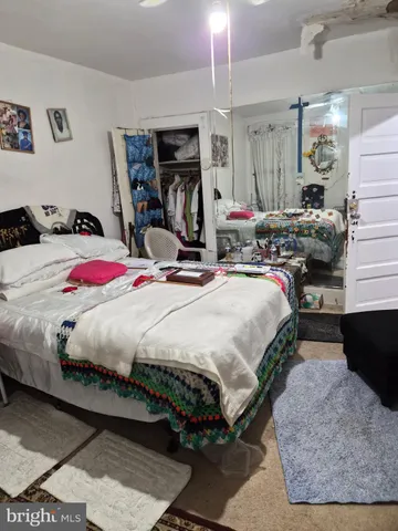 a bedroom with bed mirror and window