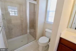 a bathroom with a shower a toilet and a window