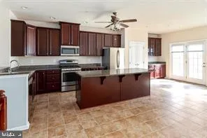 a kitchen with stainless steel appliances granite countertop a stove top oven a sink a refrigerator and a granite counter tops