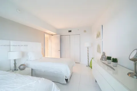 a spacious bedroom with a bed and a cabinets