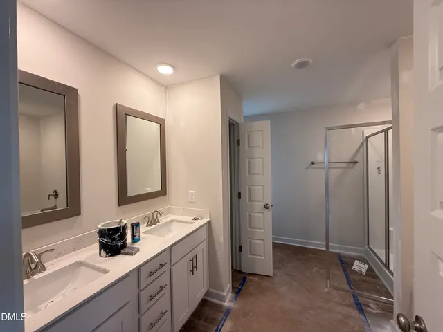 a bathroom with a double vanity sink mirror and shower