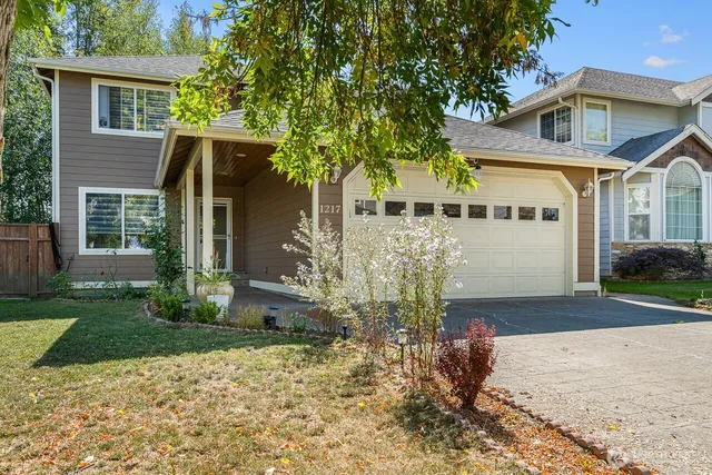 a front view of a house with a yard and potted plants