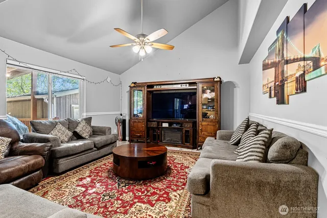 a living room with furniture a ceiling fan and a window
