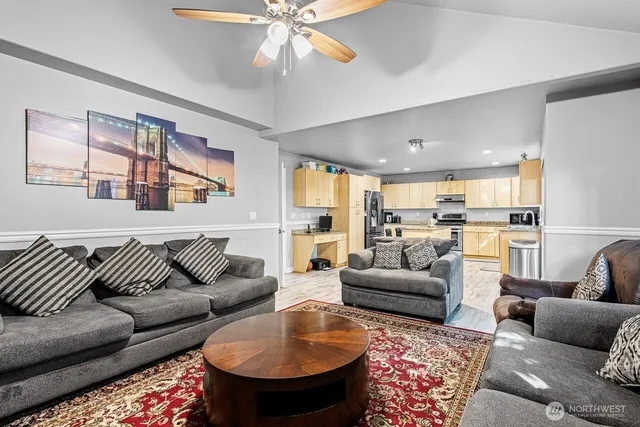 a living room with furniture and a view of kitchen