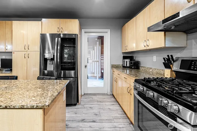 a kitchen with stainless steel appliances granite countertop a stove and a refrigerator