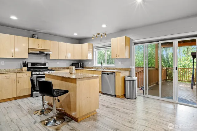 a kitchen with a sink a counter top space appliances and cabinets