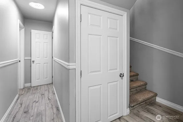 a view of a hallway with wooden floor and entryway