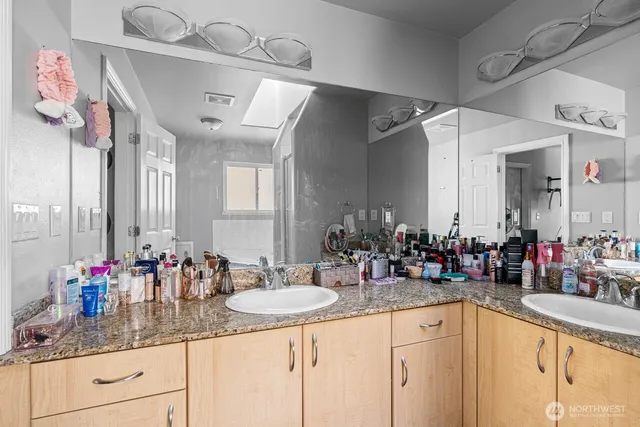 a bathroom with a granite countertop sink a large mirror and a shower