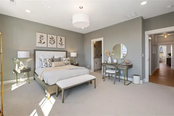 a bedroom with a bed a table and painting on the wall