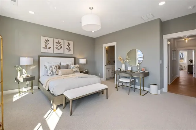 a bedroom with a bed a table and painting on the wall