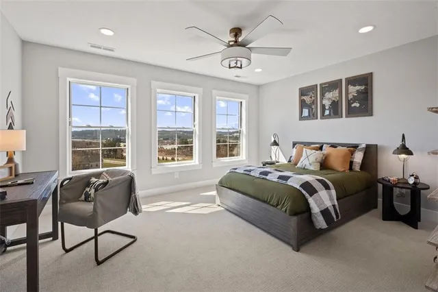 a spacious bedroom with a bed and glass window