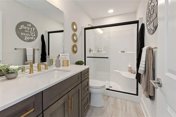 a bathroom with a sink a toilet and a large mirror