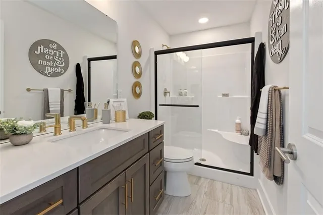 a bathroom with a sink a toilet and a large mirror